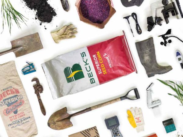 Flat-lay photograph of Beck's seed bags, tools and soil on white